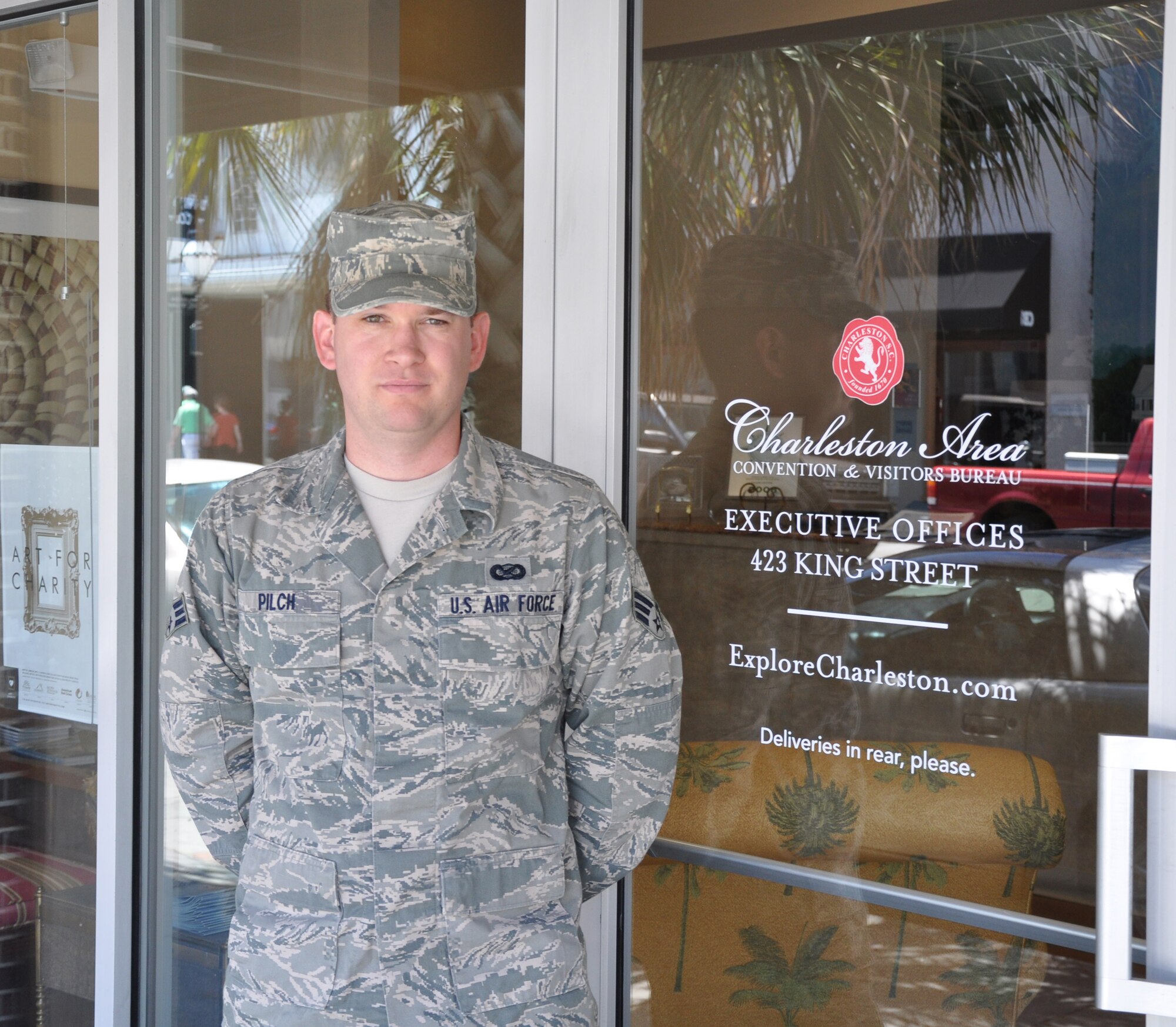 Senior Airman Bobby Pilch, a reservist with the 315th Airlift Wing Public Affairs stands by the entrance to his civilian employer, the Charleston Area Convention and Visitors Bureau. (U.S. Air Force Photo/Kevin McManus)