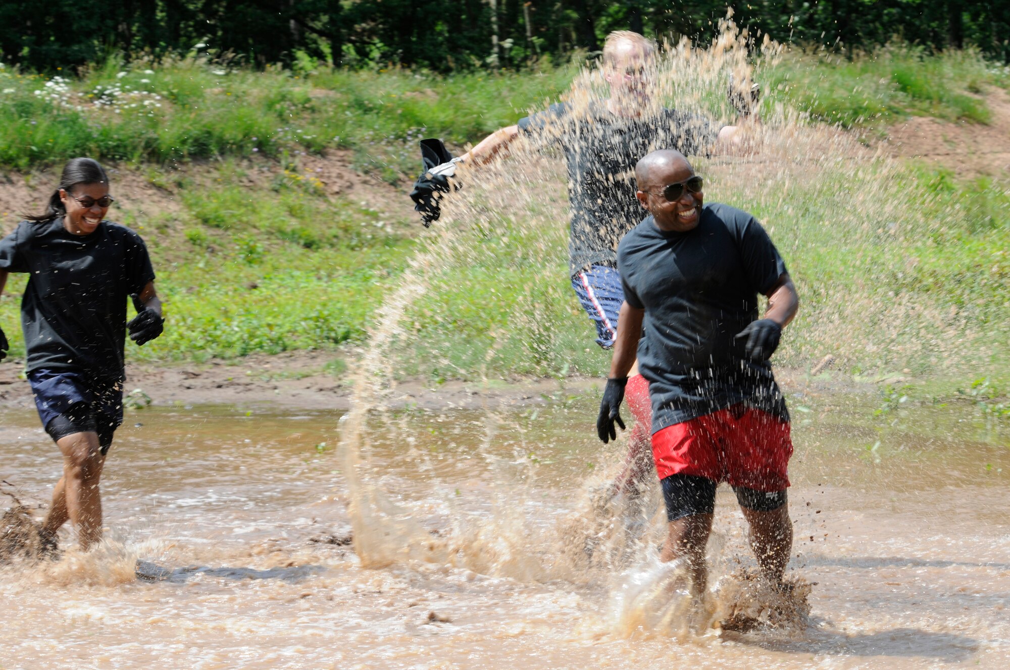 SPANGDAHLEM AIR BASE, Germany – William Byrd, 52nd Medical Group, runs through a pond with his team, Bogaard & Friends, during the Saber Endurance Challenge here June 3. Teams of five were judged on team creativity, guessing their time and money raised. Students from Bitburg High School guessed their time closest within four minutes of estimated completion. Team Soup Kitchen from the 52nd Equipment Maintenance Squadron was awarded most creative, and Team MDSS from the 52nd Medical Group raised the most money. The challenge was hosted by the Tier II council and raised money for the Wounded Warrior Project at Landstuhl Regional Medical Center, Germany. (U.S. Air Force photo/Airman 1st Class Brittney Frees)