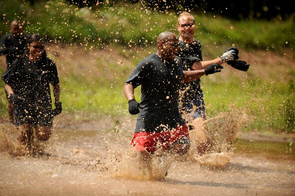 SPANGDAHLEM AIR BASE, Germany – William Byrd, center, 52nd Medical Group, runs through a pond with his team, Bogaard & Friends, during the Saber Endurance Challenge here June 3. Teams of five were judged on team creativity, guessing their time and money raised. Students from Bitburg High School guessed their time closest within four minutes of estimated completion. Team Soup Kitchen from the 52nd Equipment Maintenance Squadron was awarded most creative, and Team MDSS from the 52nd MDG raised the most money. The challenge was hosted by the Tier II council and raised money for the Wounded Warrior Project at Landstuhl Regional Medical Center, Germany. (U.S. Air Force photo/Senior Airman Nathanael Callon)