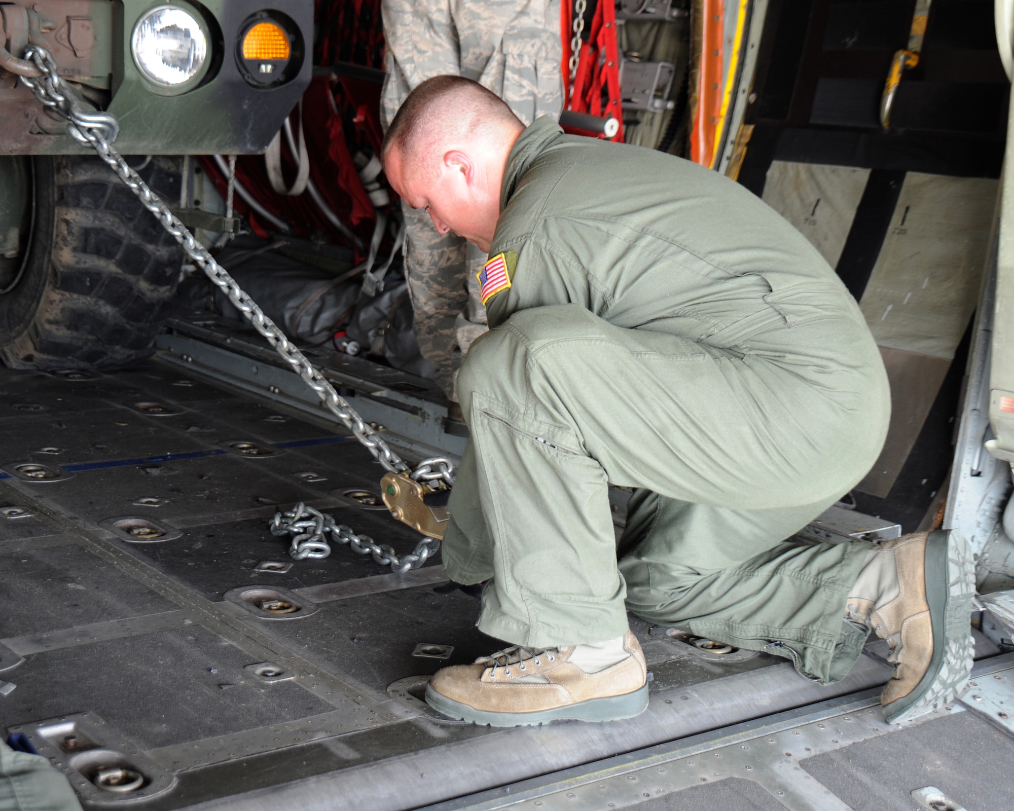 Staff Sgt. Josh Walker, 105th Airlift Squadron, 118th Airlift Wing, attaches a chain to a HIMARS vehicle to secure it into a C-130 aircraft June 4, 2011. Altogether, 16 HIMARS with the Tennessee Army National Guard's 1/181st Field Artillery Battalion were flown in four 118th AW C-130s from the Volunteer Training Site in Smyrna to Fort Chaffee, Ark. for the Army unit's annual training.