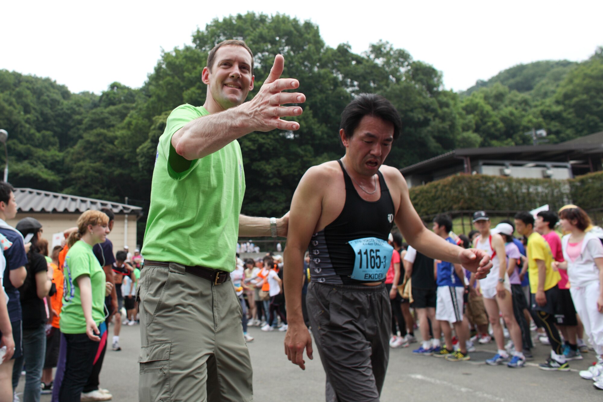 INAGI CITY, Japan -- The Yokota Striders Running Club sponsored the 27th Yokota Ekiden at the Tama Hills Recreation Area June 5, 2011. This is the first time the race was hosted at Tama Hills. More than 4,000 runners participated in the 2K kid's fun, the 5K run, and the 4x4 kilometer Ekiden relay main event. Col. Todd Freece (left), 374th Mission Support Group commander, volunteered as a guide for runners during the relay zone. (U.S. Air Force photo/Osakabe Yasuo)