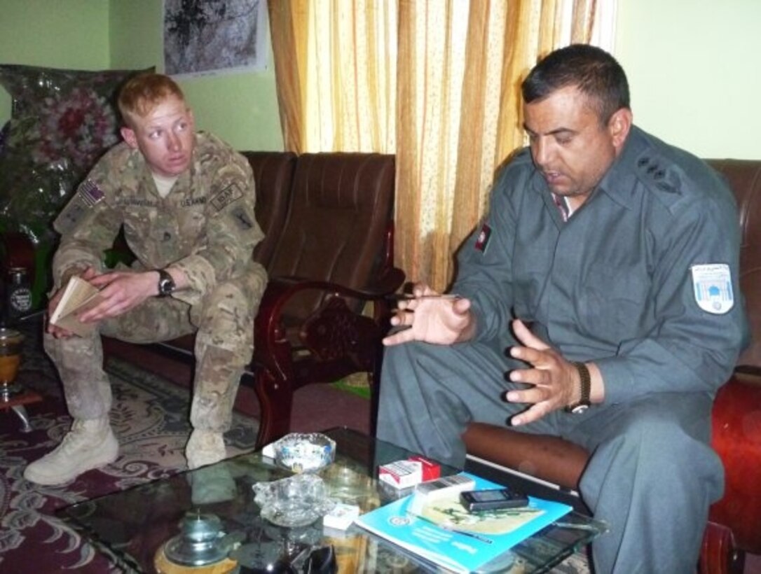 Army Staff Sgt. Tim Brewer meets with Police District 16 Police Chief Sayeed Farooq Sadat in his office to discuss operations. NATO photo by Jon Connor