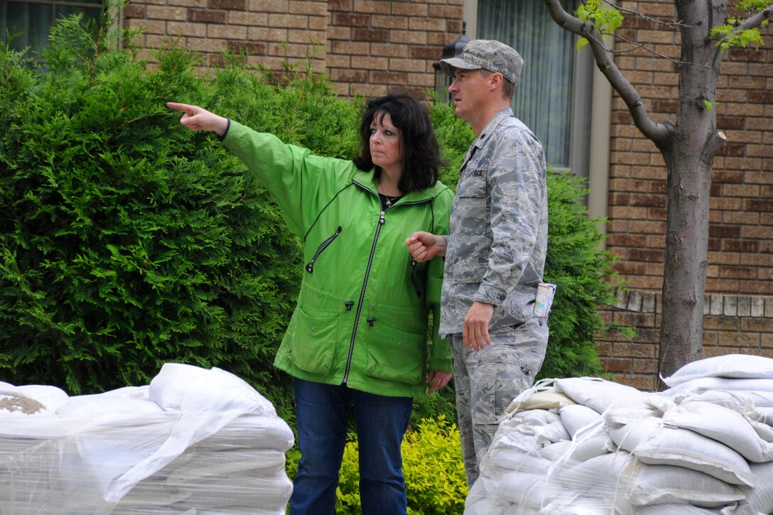 Air Force Lt. Col. Robert Schulte listens to Sonia Lunardi talk about the flood situation at her home in Bismarck, N.D., June 2, 2011. Schulte is assigned to the North Dakota National Guard's 119th Wing.