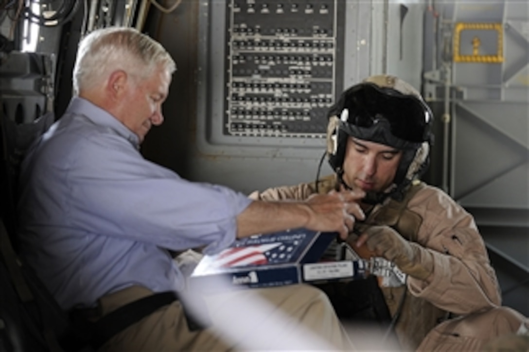 Secretary of Defense Robert M. Gates signs a U.S. Flag for a crewmember on a V-22 Osprey enroute to a Forward Operating Base in Afghanistan on June 5, 2011.  