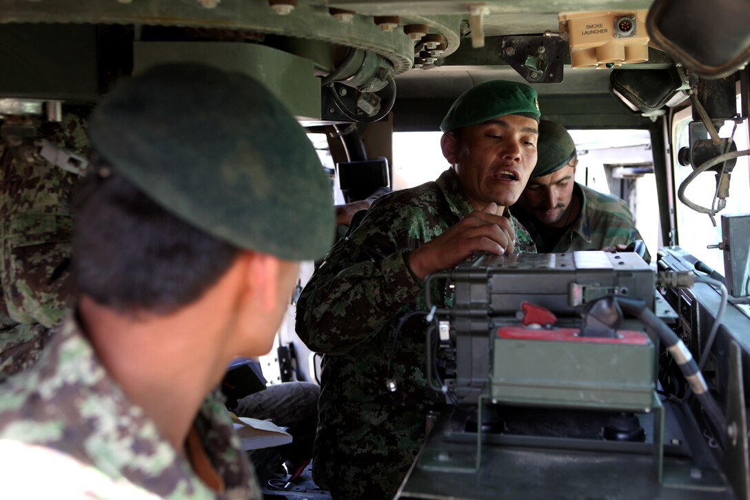 Sgt. Khair Mohammad, a basic radio operator instructor with 215th Corps Logistics Battalion, Afghan National Army, instructs a group of soldiers on the PRC-1077 radio June 7, 2011, aboard Camp Shorabak, Afghanistan.  This portion of the curriculum was the final test of a week-long basic radio operator instructor course taught by Marines with the Embedded Partnering Team, 2nd Maintenance Battalion, 2nd Marine Logistics Group (Forward).  Khair is one out of six soldiers to graduate from the course and is now capable of teaching his fellow ANA soldiers basic radio operations.