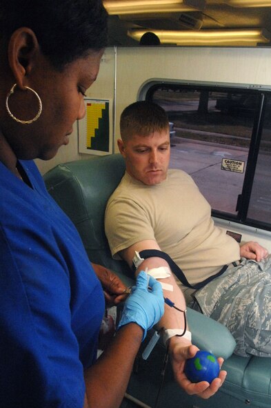 A LifeShare Blood Center employee begins the blood-donation on Tech. Sgt. Kyle Terro, 372nd Training Squadron. Sergeant Terro donated blood on Barksdale Air Force Base, La. June 7. (U.S. Air Force photo/Senior Airman Allison M. Boehm)(RELEASED)
