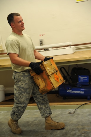 Tech. Sgt. Roy Foster carries the demolition charges to the munitions inspection table on Joint Base Charleston June 2.  The demolition charges will be inspected prior to shipment to another base. The inspection includes making sure all markings and quantities are correct for shipment. Sergeant Foster is from the 437th Maintenance Squadron's Munitions Shop.  (U.S. Air Force photo/ Staff Sgt. Nicole Mickle)  