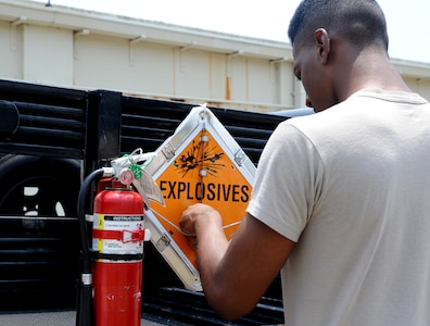 Airman Arnold Stone-Patterson changes the placard on a truck to "Explosives" on Joint Base Charleston June 2. Changing the placard on the vehicle is a requirement so everyone knows there is an explosive-laden vehicle and to stay clear. Airman Stone-Patterson is from the 437th Maintenance Squadron's Munition Shop.  (U.S. Air Force photo/ Staff Sgt. Nicole Mickle)  