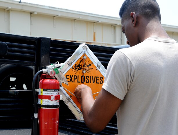 Airman Arnold Stone-Patterson changes the placard on a truck to "Explosives" on Joint Base Charleston June 2. Changing the placard on the vehicle is a requirement so everyone knows there is an explosive-laden vehicle and to stay clear. Airman Stone-Patterson is from the 437th Maintenance Squadron's Munition Shop.  (U.S. Air Force photo/ Staff Sgt. Nicole Mickle)  