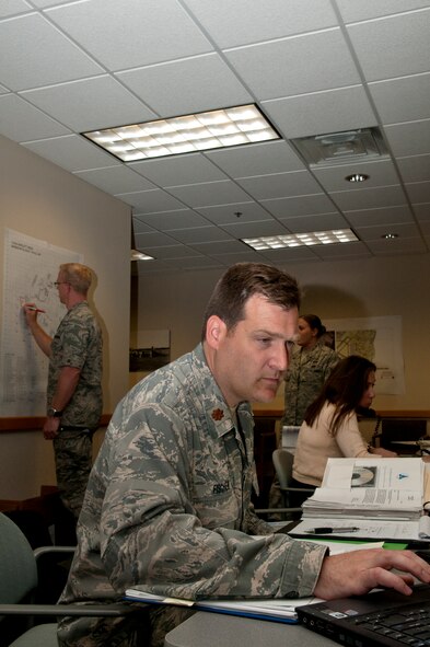 Maj. Georg Fischer checks the status of an event on his laptop during an exercise on base June2, 2011. Fischer is the Base Bioenvironmental Engineer and functions as a member of the Emergency Operations Center team for exercises and real-world situations. Photo by Moss