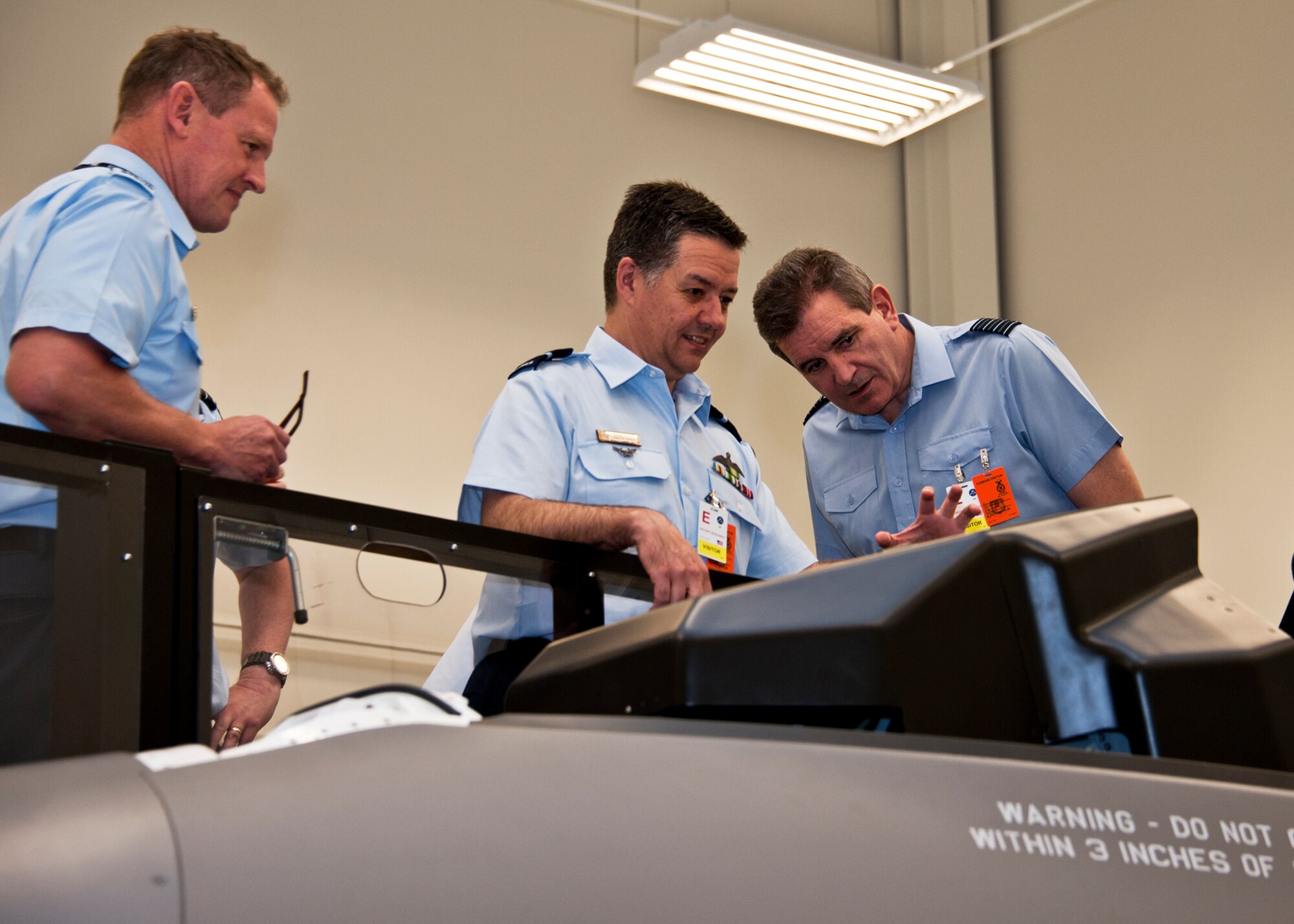 Members of the Air Space Interoperability Council observe the F-35 ejection seat maintenance trainer during their tour of the Joint Strike Fighter academic training center June 6 at Eglin Air Force Base, Fla. ASIC is an assembly of leaders from the air forces of Australia, Canada, New Zealand, the United Kingdom and the United States. The objective of the group is to ensure member nations are able to integrate seamlessly in joint and combined operations. Eglin played host to the ASIC members for their annual national directors meeting. (U.S. Air Force photo/Samuel King Jr.)