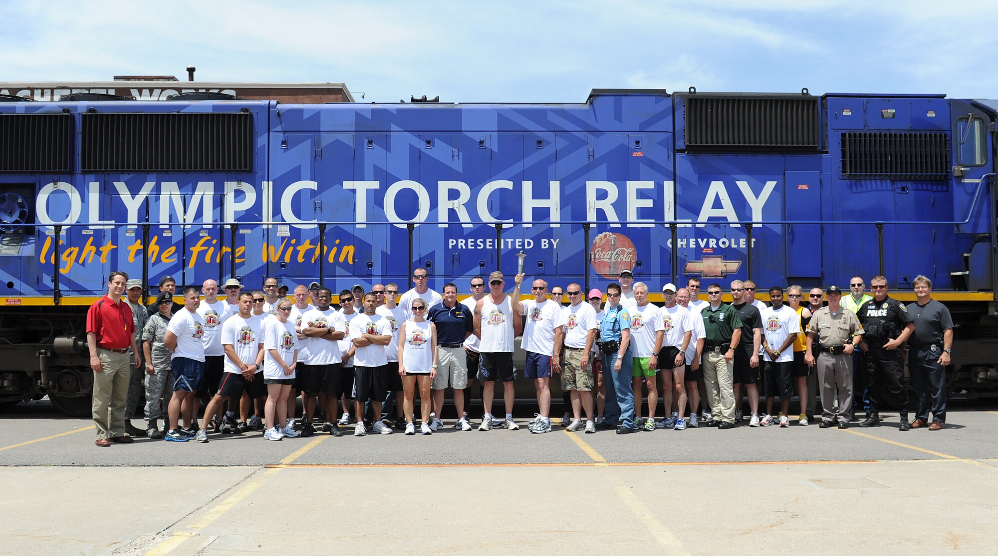 McConnell’s 22nd Security Forces Squadron members stand with Law Enforcement Torch Run participants June 3, 2011, Wichita, Kan.  The Law Enforcement Torch Run began in 1981.  Then-Wichita Police Chief Richard LaMunyon saw the need to raise funds and increase awareness for the Special Olympics World Summer and Winter Games.  McConnell members ran 12 miles, beginning in Derby, Kan., and ending in downtown Wichita. (U.S. Air Force Photo/Airman 1st Class Katrina M. Brisbin)