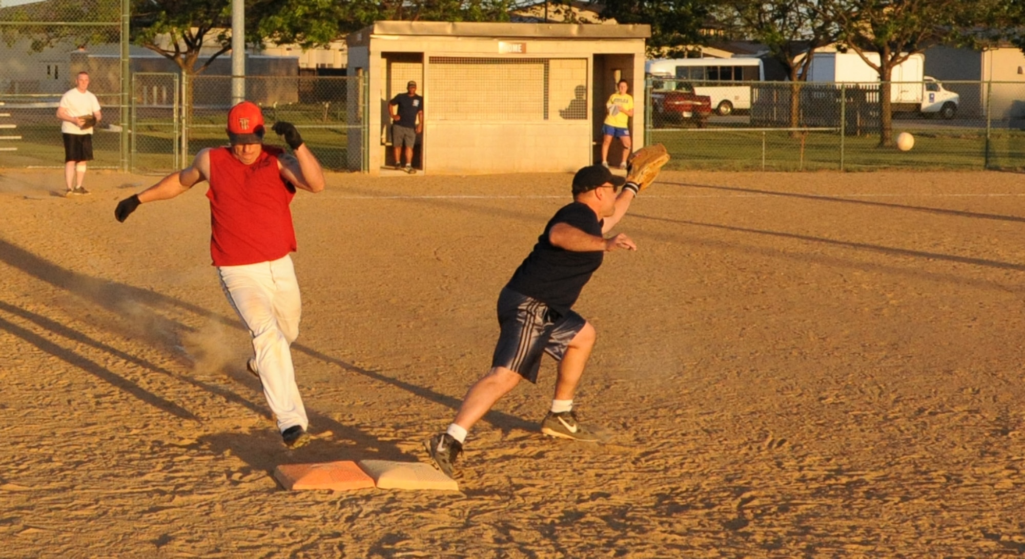(Left) Steven Peaper, 436th Civil Engineer Squadron coach, beats the ball to first base during an intramural softball game against the 436th Operations Support Squadron June 2, 2011 at Dover Air Force Base, Del.  436 CES defeated 436 OSS 11 – 0.  (U.S. Air Force photo by Staff Sgt. Chad Padgett)