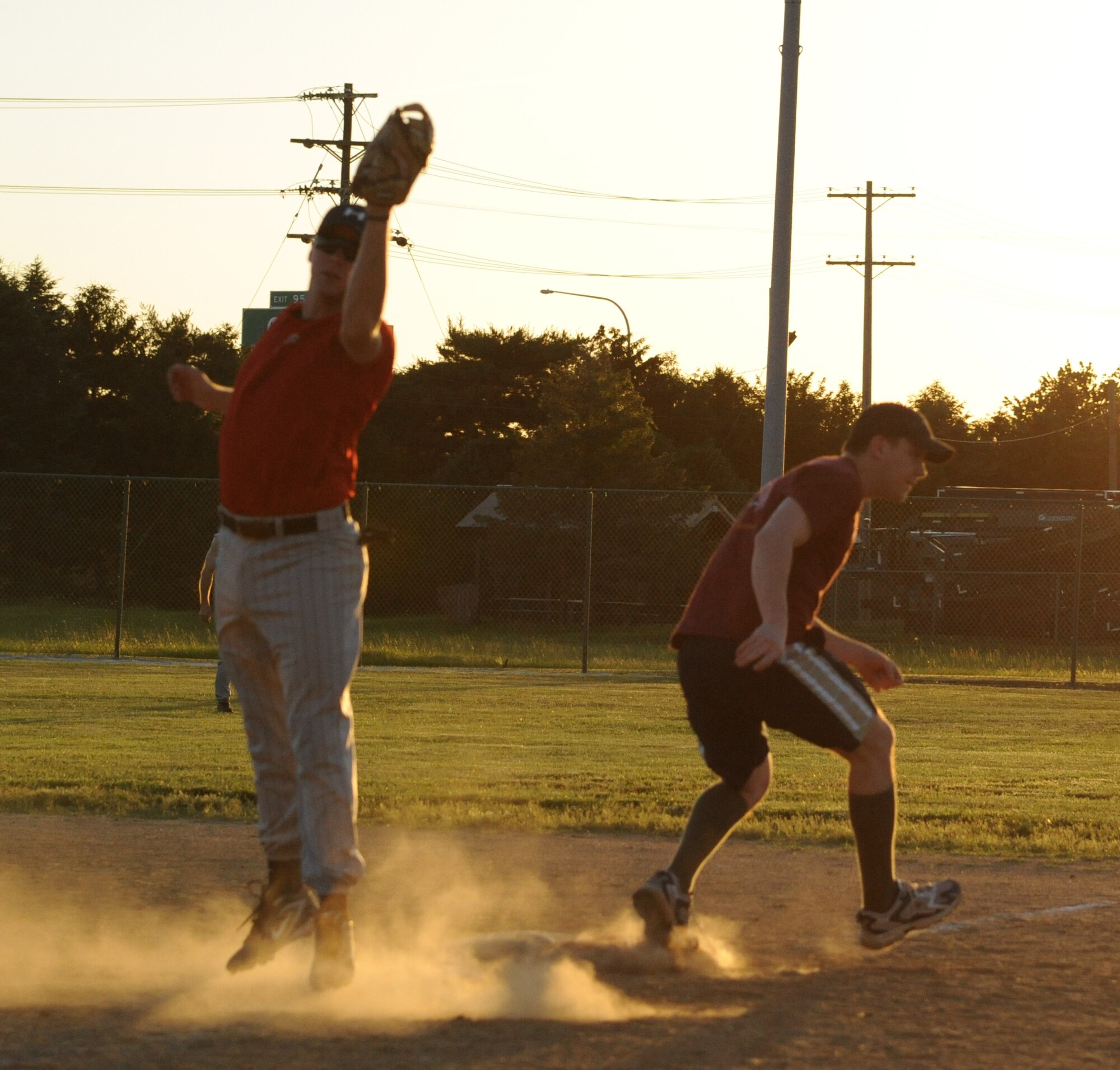 (Right) Daniel Triglianos, 436th Operations Support Squadron center fielder, slips past Chad Diehl, 436th Civil Engineer Squadron first baseman, during intramural softball June 2, 2011 at Dover Air Force Base, Del.   436 CES defeated 436 OSS 11 – 0.  (U.S. Air Force photo by Staff Sgt. Chad Padgett)