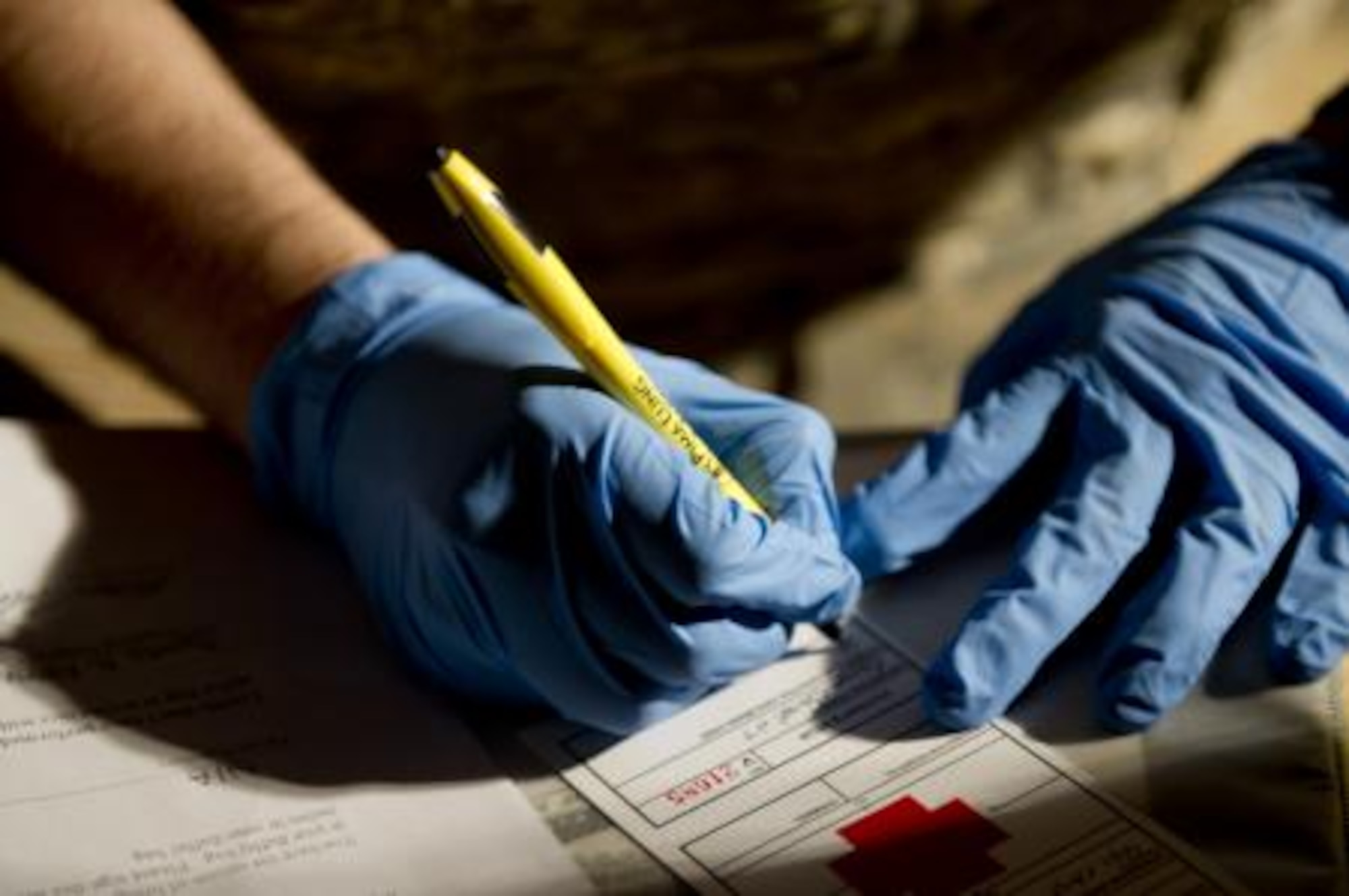 Airman 1st Class Dennis Nellessen, 451st Expeditionary Aeromedical Evacuation Squadron Detachment 1 Contingency Aeromedical Staging Facility, aerospace medical technician, fills out a luggage ID tag prior to searching the bag of a wounded Marine for any potentially dangerous or contraband items during an anti-hijacking check before loading wounded Marines onto a C-130 Hercules at Camp Bastion, Afghanistan May 26, 2011. The CASF team is responsible for taking care of patients and transporting them from the staging facility and hospital to a waiting aircraft who are then taken to the next level of medical care. (U.S. Air Force photo by Master Sgt. Adrian Cadiz/Released)
