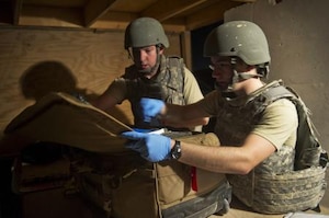 Senior Airman Cyril McKenney, left, and Airman 1st Class Dennis Nellessen, 451st Expeditionary Aeromedical Evacuation Squadron Detachment 1 Contingency Aeromedical Staging Facility aerospace medical technicians, search the bag of a wounded Marine for any potentially dangerous or contraband items during an anti-hijacking check prior to loading wounded Marines onto a C-130 Hercules at Camp Bastion, Afghanistan, May 26, 2011. Airmen McKenney and Nellessen are deployed from the 633d Medical Operations Squadron, Joint Base Langley-Eustis, Va. Airman 1st Class Dennis Nellessen, 451st Expeditionary Aeromedical Evacuation Squadron Detachment 1 Contingency Aeromedical Staging Facility, aerospace medical technician, searches the bag of a wounded Marine for any potentially dangerous or contraband items during an anti-hijacking check prior to loading wounded Marines onto a C-130 Hercules at Camp Bastion, Afghanistan. The CASF team is responsible for taking care of patients and transporting them from the staging facility and hospital to a waiting aircraft who are then taken to the next level of medical care. Airman Nellessen is deployed from the 633rd Medical Operations Squadron, Joint Base Langley-Eustis, Va. (U.S. Air Force photo by Master Sgt. Adrian Cadiz/Released)