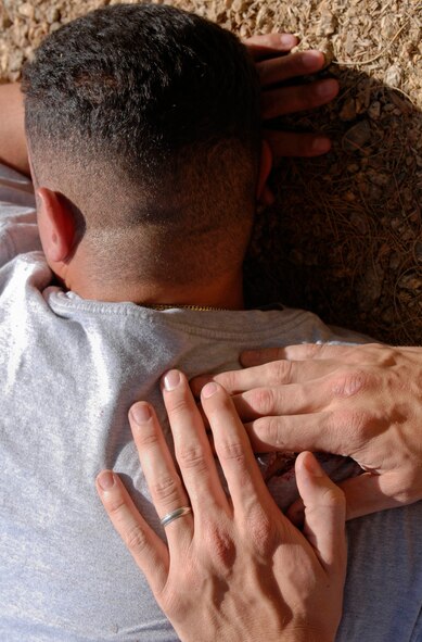 Senior Airman Aaron Peacock, 56th Component Maintenance Squadron jet engine mechanic, applies pressure to a simulated bullet would on Tech. Sgt. Lisandro Delgado, 56th CMS jet engine mechanic, during an active shooter exercise at Luke Air Force Base, Ariz., May 25, 2011. (U.S. Air Force Photo by Senior Airman Darlene Seltmann/Released)