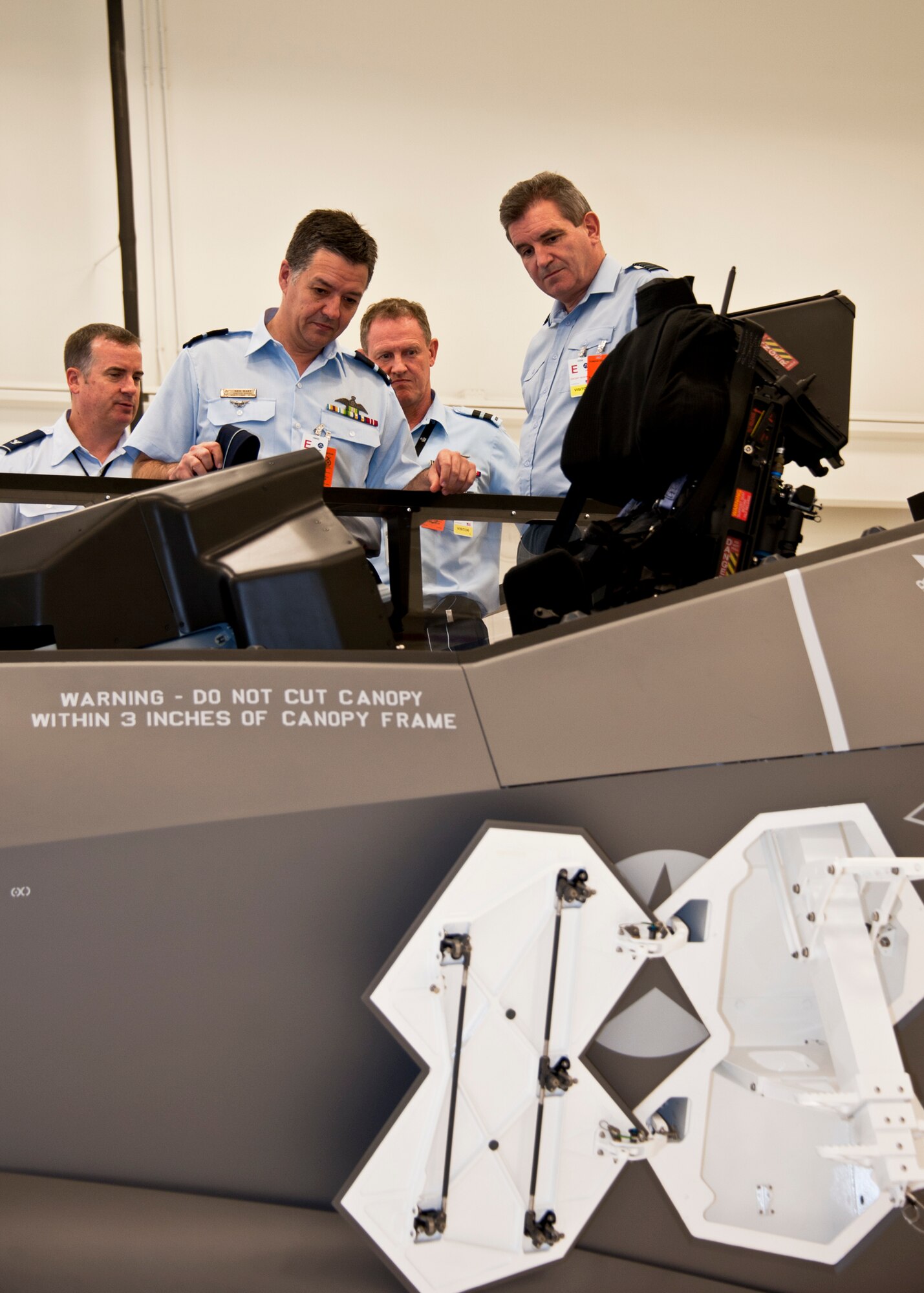 Members of the Air Space Interoperability Council observe the F-35 ejection seat maintenance trainer during their tour of the Joint Strike Fighter academic training center June 6 at Eglin Air Force Base, Fla.  ASIC is an assembly of leaders from the air forces of Australia, Canada, New Zealand, the United Kingdom and the United States.  The objective of the group is to ensure member nations are able to integrate seamlessly in joint and combined operations.  Eglin played host to the ASIC members for their annual national directors meeting.  (U.S. Air Force photo/Samuel King Jr.)