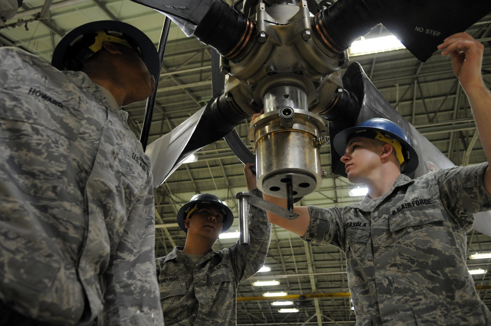 YOKOTA AIR BASE, Japan -- (left to right) Staff Sgt. Greg Howard, Staff Sgt. Ulysses Manduriao, and Senior Airman Charles Guisasola, from the 374th Maintenance Squadron Propulsion Flight aerospace propulsion craftsman, apply a post test adapter to a propeller during an Initial Readiness Response Exercise at Yokota Air Base, Japan, June 7, 2011. The post test adapter test C-130 Hercules propeller blade angles and internal leakage. (U.S. Air Force photo/Airman 1st Class Krystal M. Garrett) 