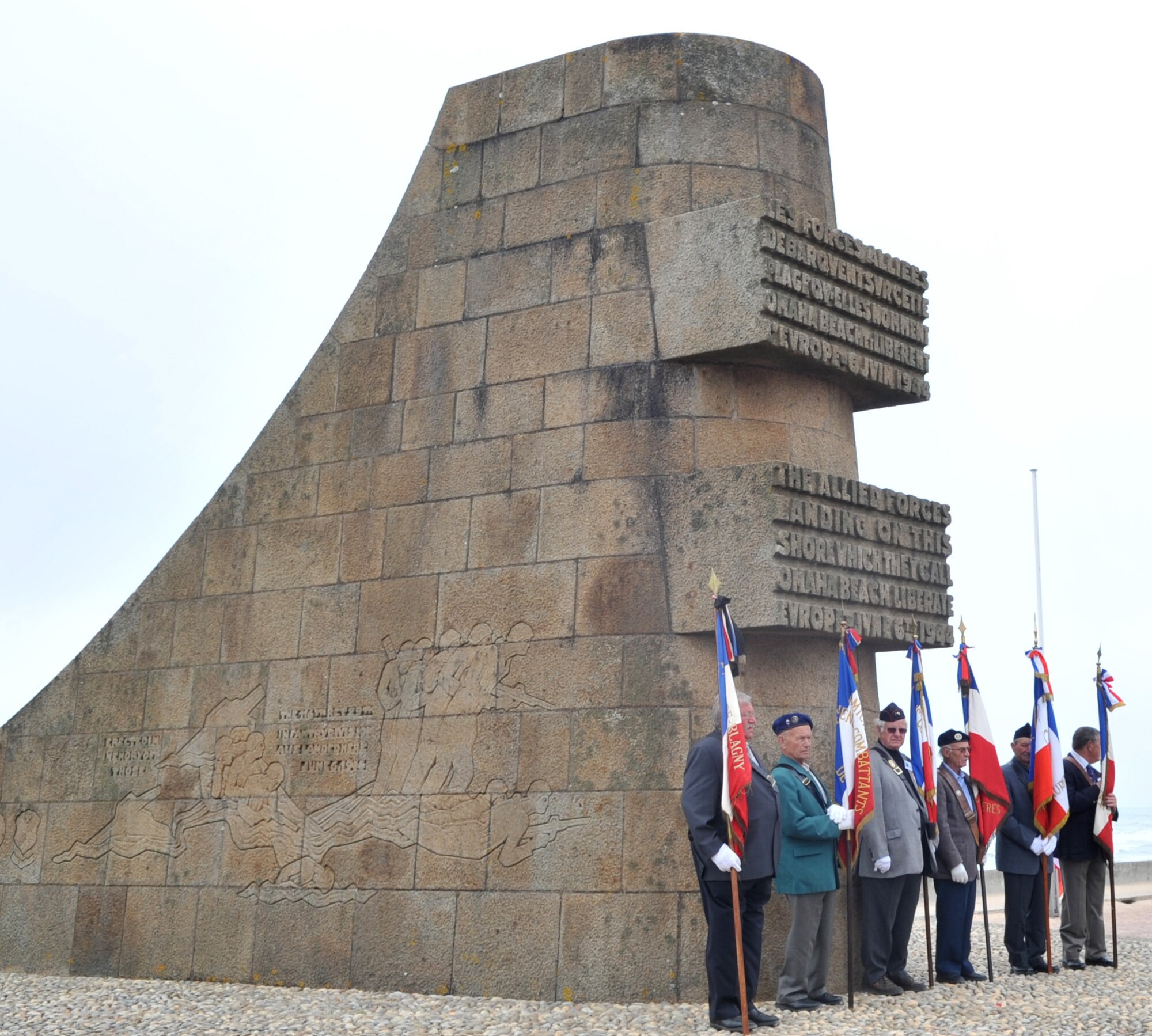 World War II veterans stand at a memorial during a ceremony on Omaha Beach, France for the 67th Anniversary of D-Day, June 4, 2011. Each year since the liberation of Normandy, U.S. forces along with allied nations come together to honor those who gave the ultimate sacrifice on that day. This year's ceremony is scheduled to be attended by dozens of American World War II veterans. (U.S. Air Force photo by Senior Airman Caleb Pierce)