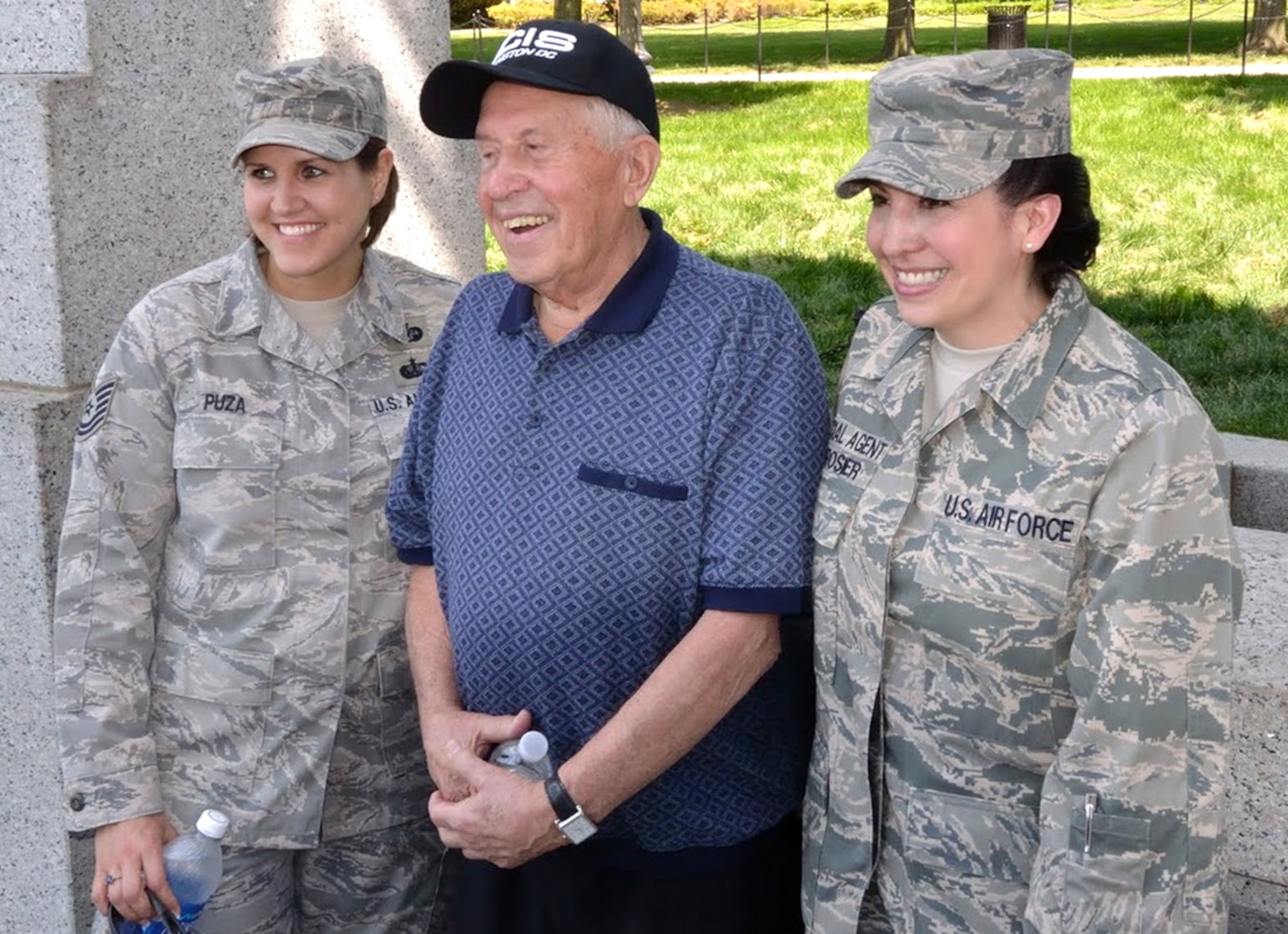Air Force Office of Special Investigations members volunteered with the Honor Flight Network May 21 at the WW II memorial in Washington, D.C. Pictured here are Tech. Sgt. Laura Puza, left, and OSI Special Agent Karolyn Derosier, with a WW II veteran. The Honor Flight Network is a non-profit organization created to honor America's veterans. The network transports the veterans to Washington, D.C. to visit their respective memorials. OSI members attending the event helped usher the veterans around the WWII memorial. For more information on the Honor Flight Network, visit www.honorflight.org. (U.S. Air Force photo by Special Agent Jacob Barrett.)
