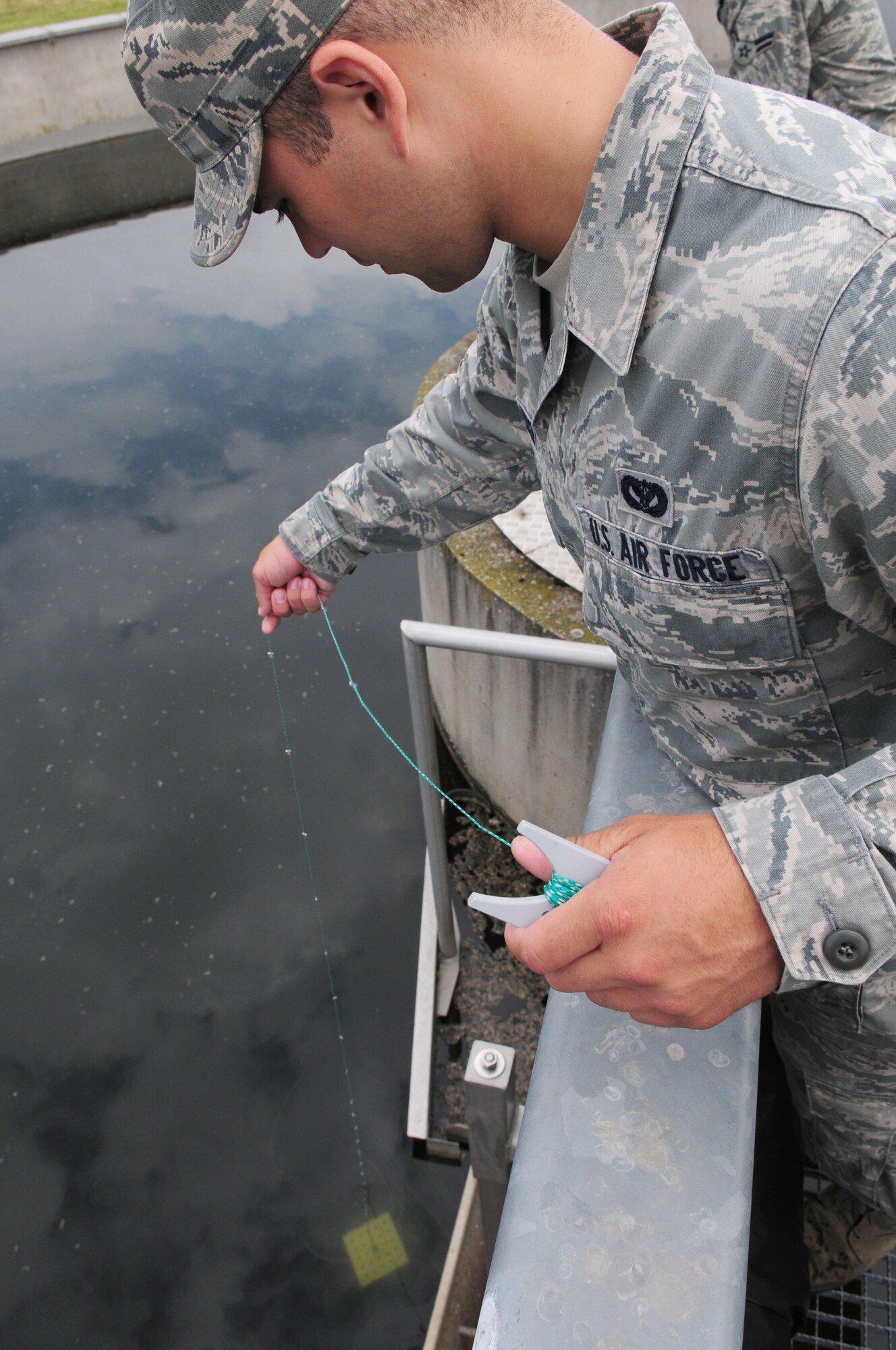 SPANGDAHLEM AIR BASE, Germany – Airman 1st Class Andrew Herget, 52nd Civil Engineer Squadron water and fuel systems maintenance apprentice, conducts a visibility test in the clarifier tank at the water treatment facility here June 6. The facility processes wastewater from the base to remove hazardous chemicals before it is released back into the environment. (U.S. Air Force photo/Airman 1st Class Matthew B. Fredericks)