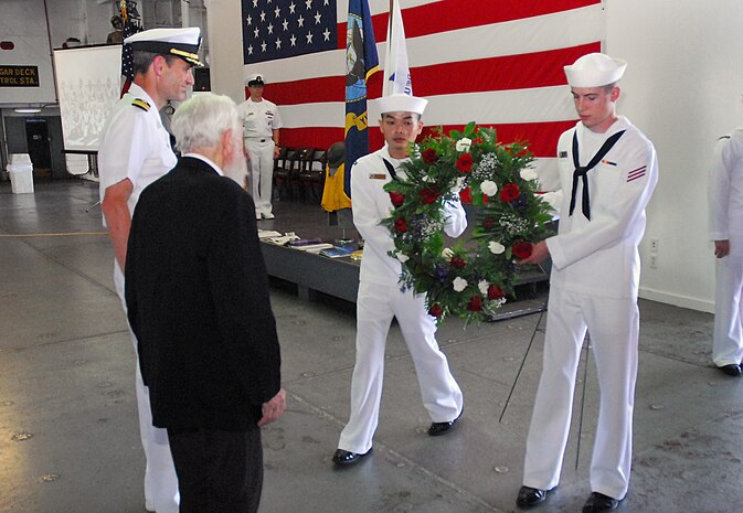 Fireman John Dyer, right, and Machinist's Mate 3rd Class Michael Phaiboun present a wreath to Capt. Ralph Ward and Rev. Harold Syfrett. The wreath was laid during the commemoration ceremony of the 69th Anniversary of the Battle of Midway onboard the USS Yorktown (CV 10) at Patriots Point Naval and Maritime Museum, June 3. The wreath laying ceremony is a tradition that honors service members who served and sacrificed. Captain Ward is the Joint Base Charleston deputy commander; Fireman Dyer and MM3 Phaiboun are assigned to Naval Support Activity, Joint Base Charleston. (U.S. Navy photo/Machinist's Mate 3rd Class Brannon Deugan)