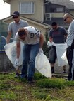 MIZUHO TOWN, Japan -- Airmen from the 374th Maintenance Group search for trash during the 29th annual Mizuho town clean up outside Yokota Air Base, Japan, June 5, 2011. Every year a team of Yokota maintainers, working in conjunction with the Mizuho-Yokota Friendship Club, attend this outreach event in order to further improve Yokota's relationship with the local community. (U.S. Air Force photo/Captain Raymond Geoffroy)