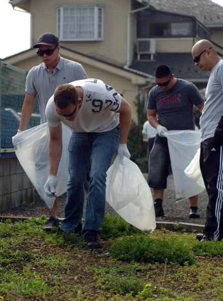 MIZUHO TOWN, Japan -- Airmen from the 374th Maintenance Group search for trash during the 29th annual Mizuho town clean up outside Yokota Air Base, Japan, June 5, 2011. Every year a team of Yokota maintainers, working in conjunction with the Mizuho-Yokota Friendship Club, attend this outreach event in order to further improve Yokota's relationship with the local community. (U.S. Air Force photo/Captain Raymond Geoffroy)