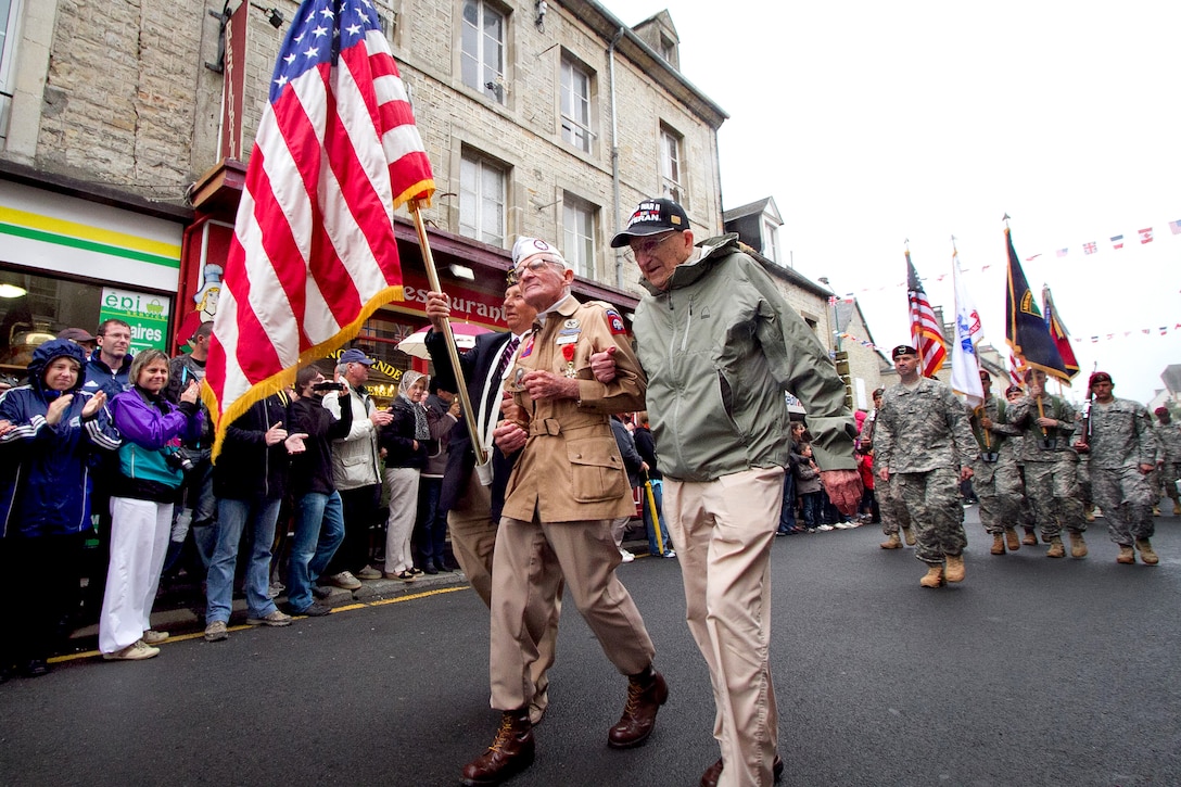Veteran U.S. Army paratrooper Zane Schlemmer wears his original jump boots as he walks down the main street of Sainte Mere Eglise with other World War II veterans during a parade commemorating the 67th anniversary of the Allied invasion of France, June 5, 2011. Schlemmer was a U.S. Army sergeant assigned to the 82nd Airborne Division when he jumped into northern France on D-Day. French citizens applaud as he parades past, joined by current 82nd Airborne Division paratroopers and soldiers from other U.S. Army units.