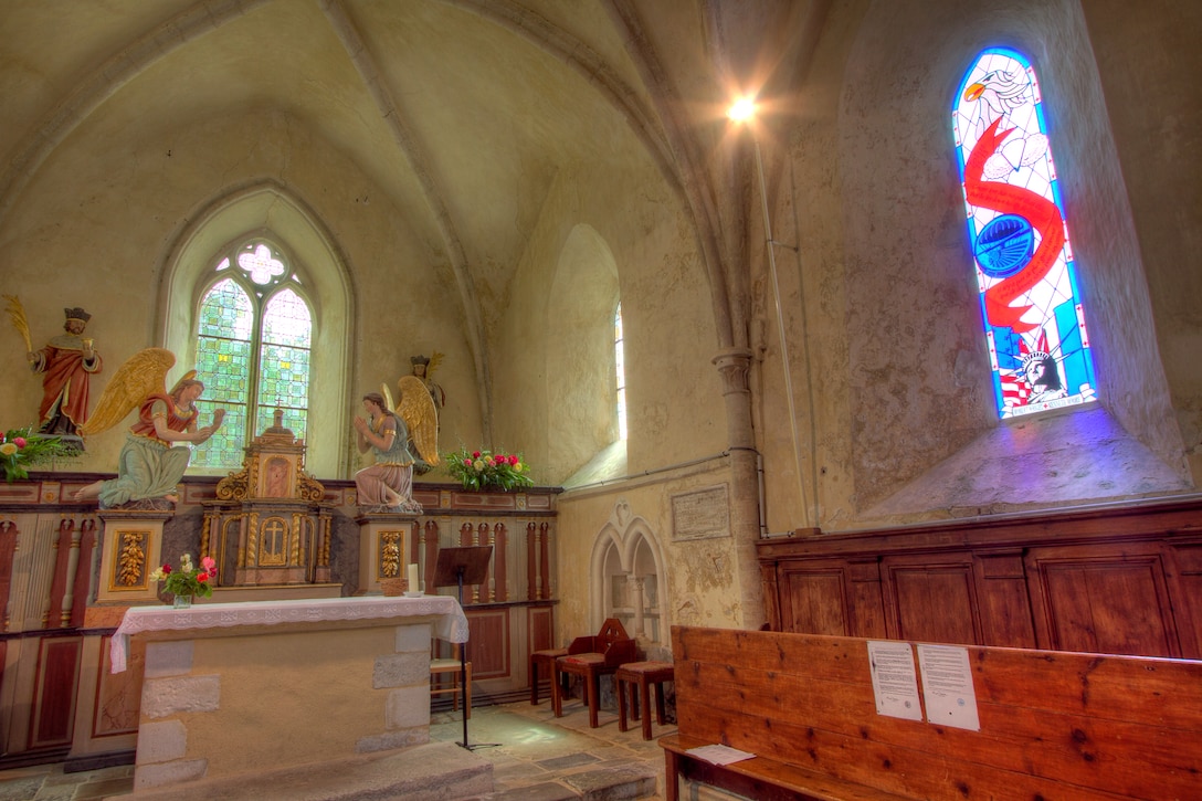 A stained-glass window in the church of Angoville-au-Plain, France, casts a light to the memory of U.S. Army paratroopers who wrested the village from the German army following the Allied invasion of France, June 6, 2011. The church was once used by U.S. Army paratroopers and medics Robert Wright and Ken Moore to care for more than 70 U.S. and German soldiers as fighting raged outside.