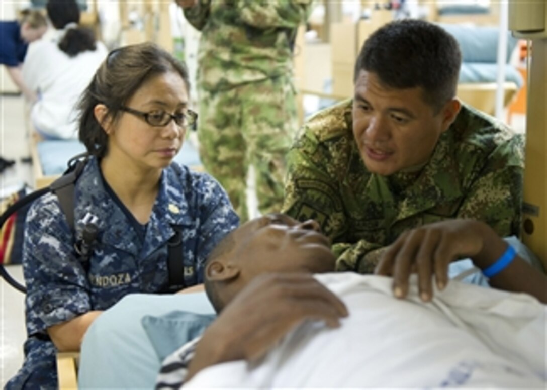 U.S. Navy Lt. Cecilia Mendoza (left) and Rev. Juan Garcia, a Roman Catholic priest from the Colombian Navy, visit a patient during a tour aboard the hospital ship USNS Comfort (T-AH 20) during Continuing Promise 2011 on June 4, 2011.  Continuing Promise is a regularly scheduled mission to countries in Central and South America and the Caribbean, where the U.S. Navy and its partnering nations work with host nations and a variety of governmental and nongovernmental agencies to train in civil-military operations.  