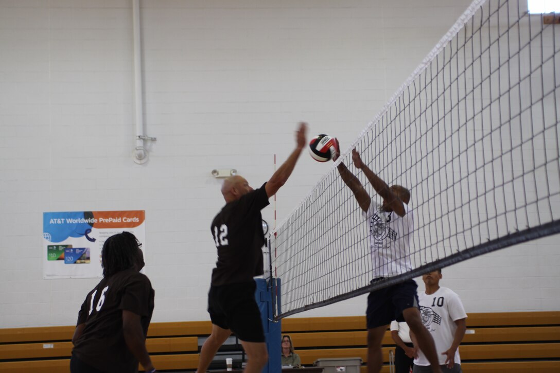 Sgt. Maj. Wayne Pedersen, Support Battalion, spikes the ball past Sgt. Benedict Baclig, orders chief for 12th Marine Corps Recruiting District, June 7, during a::r::::n::volleyball game at the Field House aboard Marine Corps Recruit Depot San Diego. The 12th District defeated the Recruit Administration Branch in the Commanding::r::::n::General’s Cup intramural sports season.