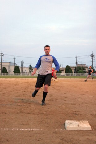 Justin M. Penn, Blue Flacons player, runs to third base against JP-5 in an intramural softball game at the main softball field here June 8. The Blue Falcons would go on to win the game with a staggering score of 30-1.