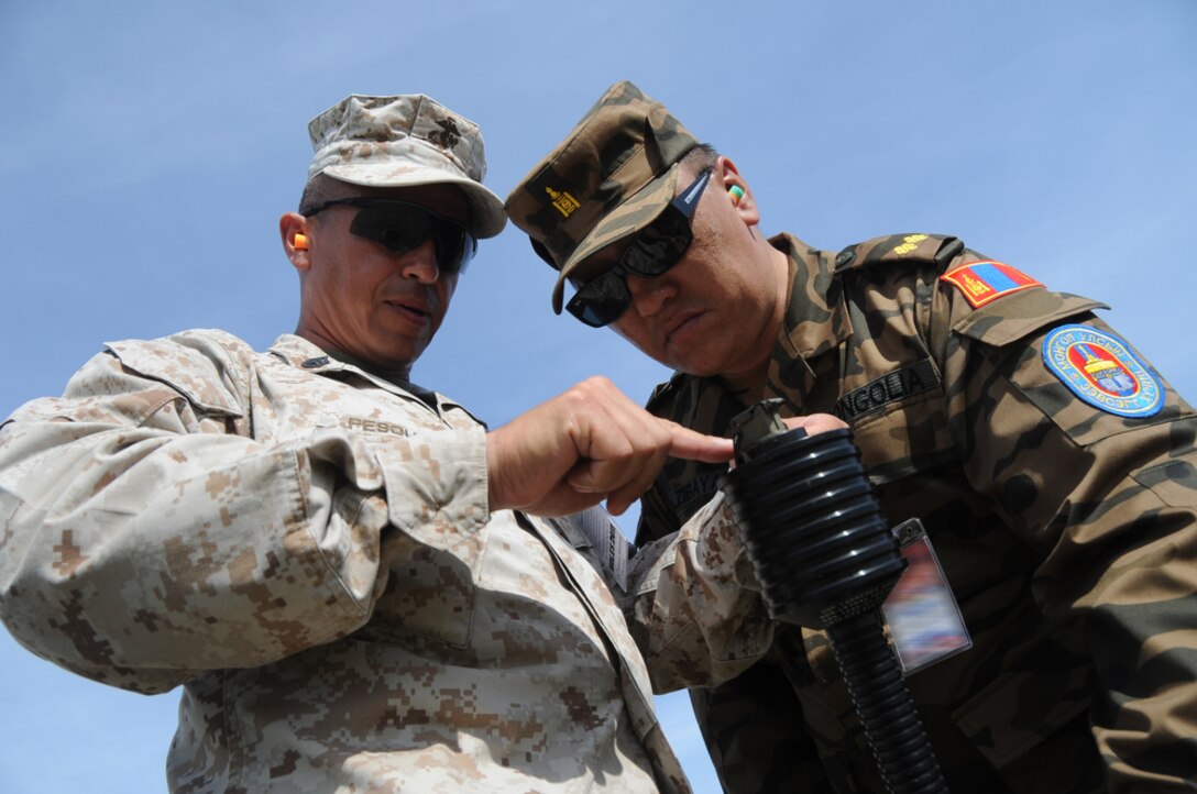 U.S. Marine Staff Sgt. Carlos Pesqueira from Special Operations Training Group, III Marine Expeditionary Force, demonstrates how to arm a non-lethal grenade to a Mongolian Army officer during Non-lethal Weapons Executive Seminar 2011(NOLES) June 8. Military representatives from around the world fired non-lethal munitions after a demonstration by Royal Thai military and police forces. NOLES, co-hosted by Thai and U.S. militaries, promotes the advancement of non-lethal capabilities by serving as a forum to exchange ideas among partner militaries.