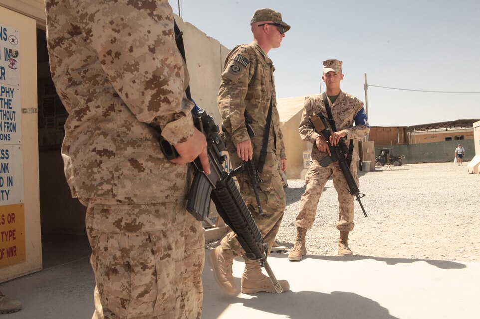 Lance Cpl. Eric Falcon, left, a Marine Attack Squadron 513 flight safety equipment mechanic and Lubbock, Texas, native, and Cpl. Shiloh Haynes, a VMA-513 powerline mechanic and Parker, Colo., native. Stand guard at one of the gyms at Kandahar Airfield, Afghanistan, June 8.