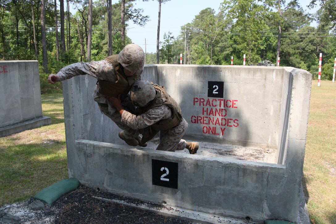 For training purposes, in case a grenade is dropped in the pit, Sgt. Cameron S. Neivert, a section leader with 2nd platoon, Battery B, 2nd Low Altitude Air Defense Battalion, tackles Petty Officer 3rd Class Kristopher W. Negel out of the pit after Negel’s grenade was tossed short during the Battery B, 2nd LAAD, grenade training at Marine Corps Base Camp Lejeune, June 8.