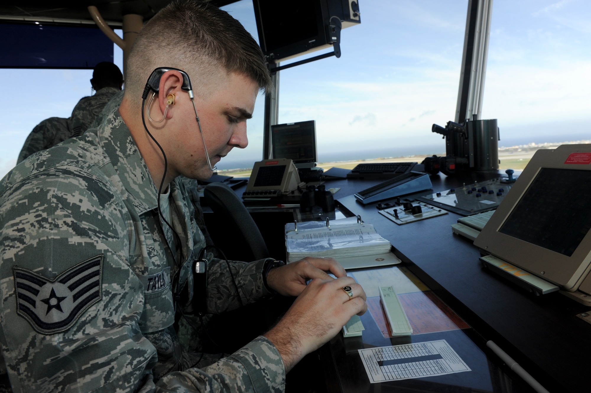 Staff Sgt. Liam Taylor, 18th Operation Support Squadron air traffic controller, changes a flight progress strip, June 7. Each strip corresponds with a different aircraft and indicates what the aircraft intends on doing. (U.S. Air Force photo/ Airman 1st Class Brooke Beers)
