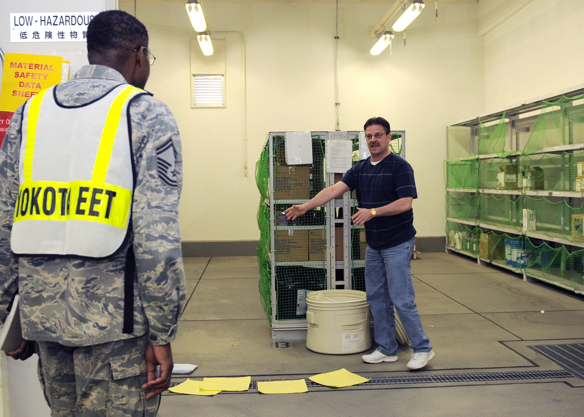 YOKOTA AIR BASE, Japan -- Senior Master Sgt. James Morrison (left), 374th Logistics Readiness Squadron exercise evaluation team member, evaluates Gary Furman, 374th LRS supply technician, during the Initial Readiness Response Exercise at Yokota Air Base, June 8, 2011. The IRRE tested Yokota's ability to respond to emergency situations. (U.S. Air Force photo/Senior Airman Andrea Salazar)