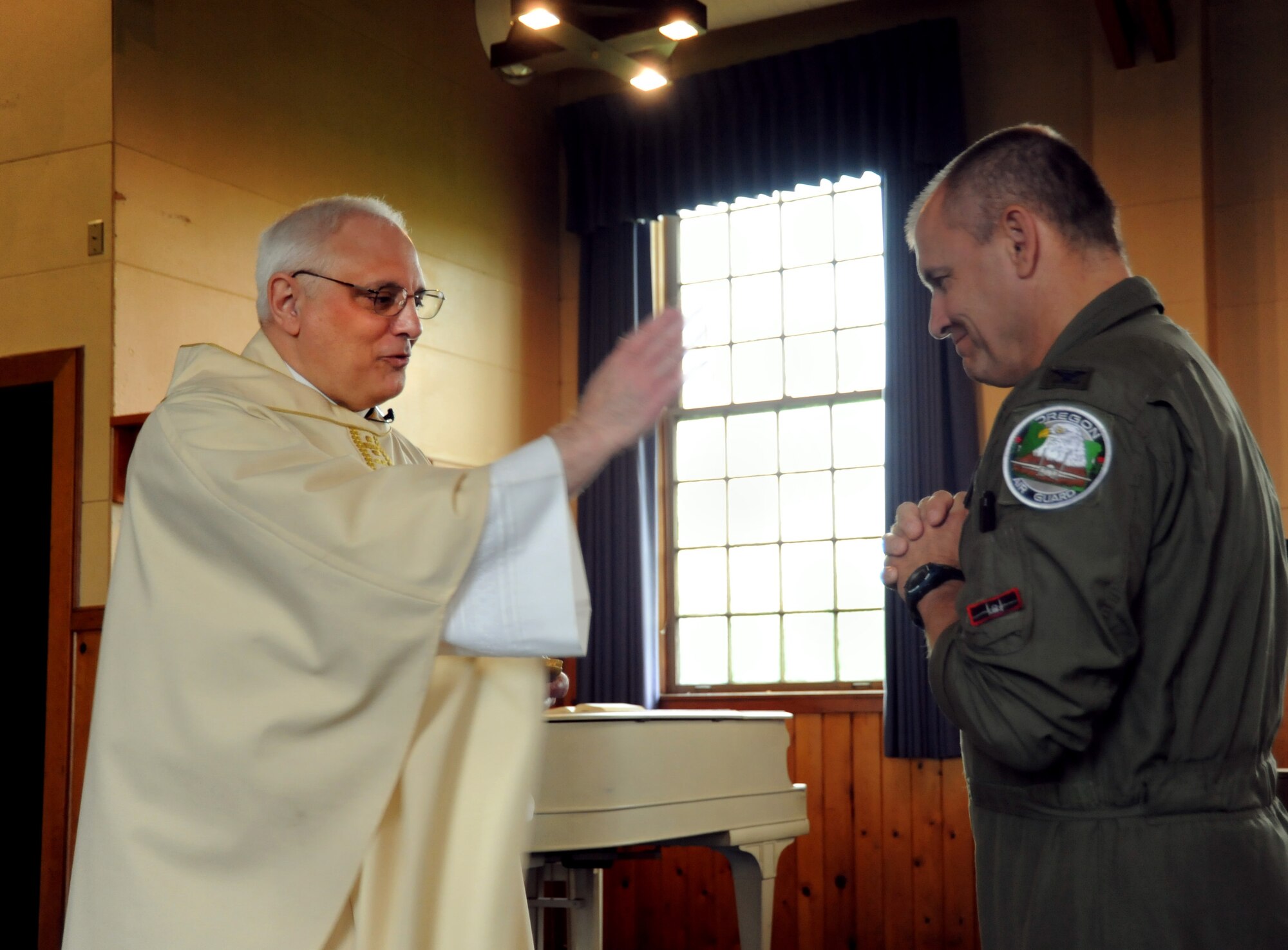 U.S. Air Force Lt. Col. Rick Sirianni gives a blessing to Col. Michael Bieniewicz, 142nd Fighter Wing Vice- Commander, during mass held on May 15, 2011 at the Portland Air National Guard Base, Portland, Ore., during the 142nd Fighter Wing Unit Training Assembly. This was Father Sirianni's last mass before he retires from the Oregon Air National Guard after 23 years of service. (U.S. Air Force photograph by Tech. Sgt. John Hughel) (Released)