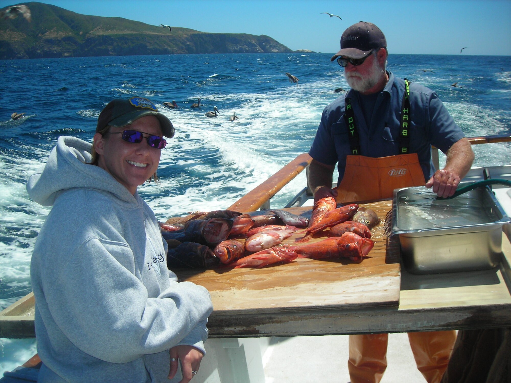 Capt. Elizabeth Evans, Air Force Operational Test and Evaluation Center Det. 5, stands by while Sean, a deckhand aboard the Erna B, cleans the fish she caught that day, May 26. Captain Evans was one of four Edwards Airmen treated to a day of deep-sea fishing after returning from a tour in Kuwait. (Courtesy photo by William (Jeff) Arnett)
