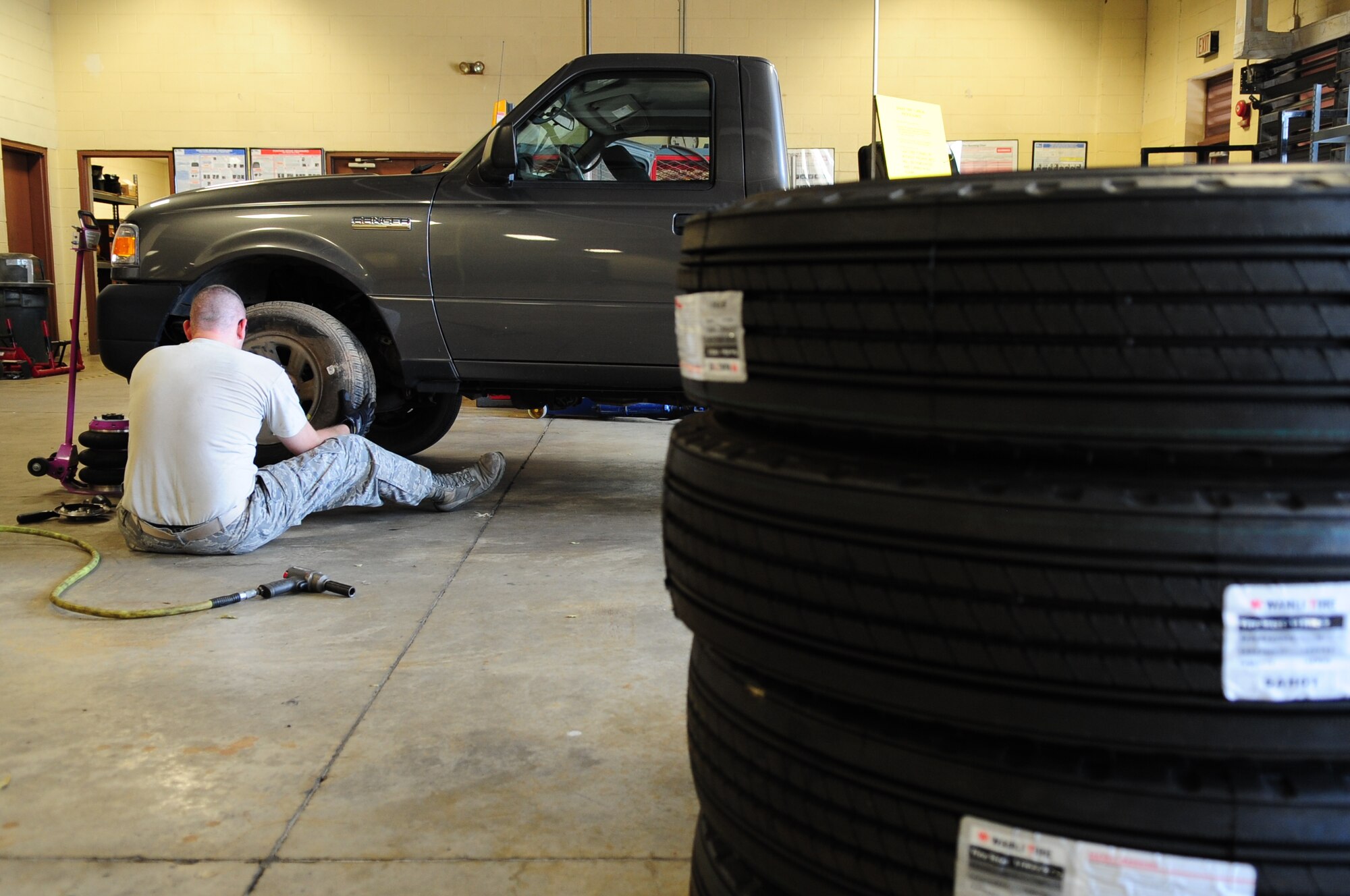 Tech. Sgt. Vincent St. Hilaire, 2nd Logistics Readiness Squadron, NCO-in-charge of allied trades, places a spare tire on a government owned vehicle at the vehicle maintenance center located on Barksdale Air Force Base, La., June 8. The vehicle was brought to the shop with a punctured tire. A spare tire was used until a new tire could be ordered and installed. (U.S. Air Force photo/Senior Airman Joanna M. Kresge)