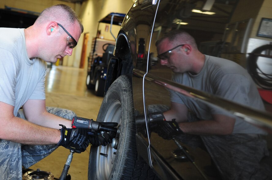 Tech. Sgt. Vincent St. Hilaire, 2nd Logistics Readiness Squadron, NCO-in-charge of allied trades, removes a flat tire from a government owned vehicle at the vehicle maintenance center located on Barksdale Air Force Base, La., June 8. The vehicle was brought to the shop with a punctured tire. A spare tire was used until a new tire could be ordered and installed. (U.S. Air Force photo/Senior Airman Joanna M. Kresge)