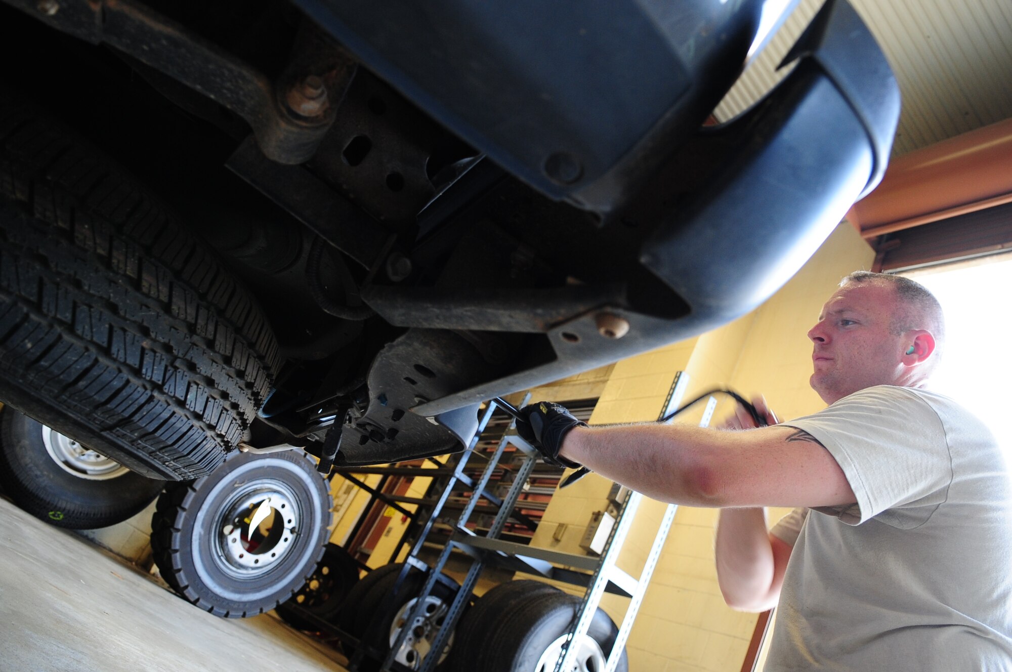 Tech. Sgt. Vincent St. Hilaire, 2nd Logistics Readiness Squadron, NCO-in-charge of allied trades, removes a spare tire from a government-owned vehicle at the vehicle maintenance center located on Barksdale Air Force Base, La., June 8. The vehicle was brought to the shop with a punctured tire. A spare tire was used until a new tire could be ordered and installed. (U.S. Air Force photo/Senior Airman Joanna M. Kresge)