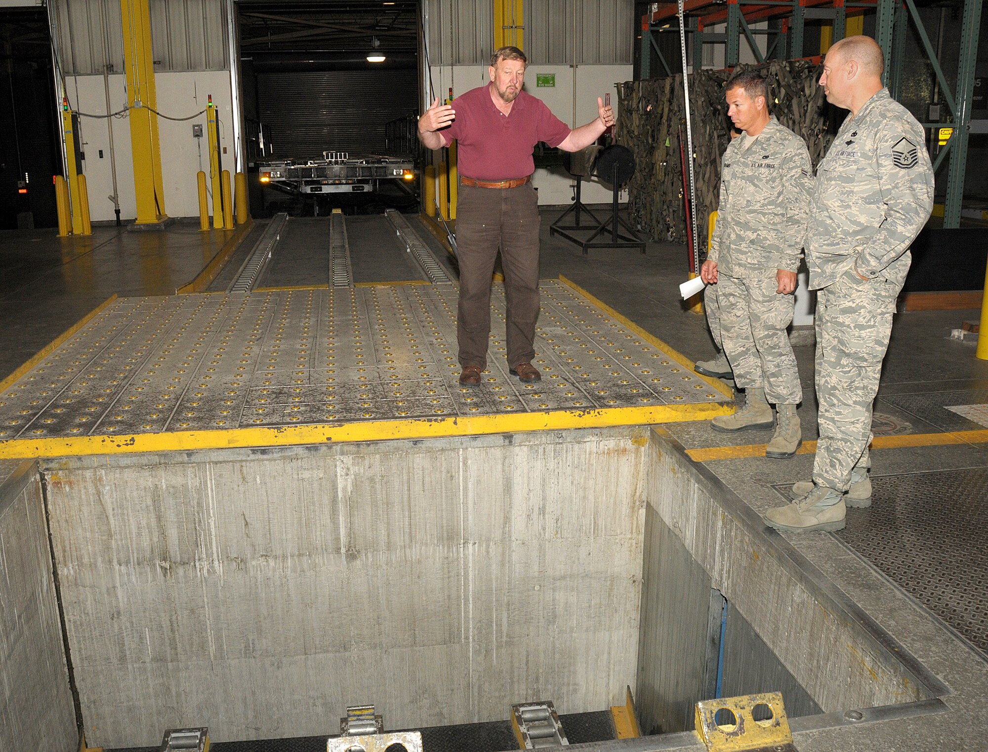 Mr, Charles Carr, Weight Supevisor 7 in Air Terminal Operations, conducts a tour of the terminal warehouse facility for Master Sergeant Burt Sherring and Airman First Class Jesse Kramer from the Air Terminal Operations Squadron, 146th Airlift Wing, Channel Islands Air National Guard Station, Calif.  on June 6, 2011. Mr. Carr briefed the members on the various equipment available to them as well as safety protocol.  The 146th AW sent three squadrons to Joint Base Elmendorf-Richardson, Anchorage, Alaska on Saturday, June 4, 2011. The Air Terminal Operations Squadron, Logistics Readiness Squadron, and the Security Force Squadron moved down range to complete there respective annual training requirements.(Photo by Tech. Sgt. Alex Koenig)