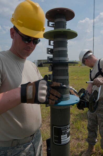 MOODY AIR FORCE BASE, Ga.-- Staff Sgt. Daniel Willetts, 823rd Base Defense Squadron client systems craftsman, ensures an antenna carrymast is level as Staff Sgt. Jeff Tregre, 823rd BDS cyber transport network specialist, lays out a cable to support the carrymast June 7. The carrymast was used as part of a training exercise to help familiarize the Airmen with setting up the equipment. (U.S. Air Force photo/Airman 1st Class Nicholas Benroth)(RELEASED)