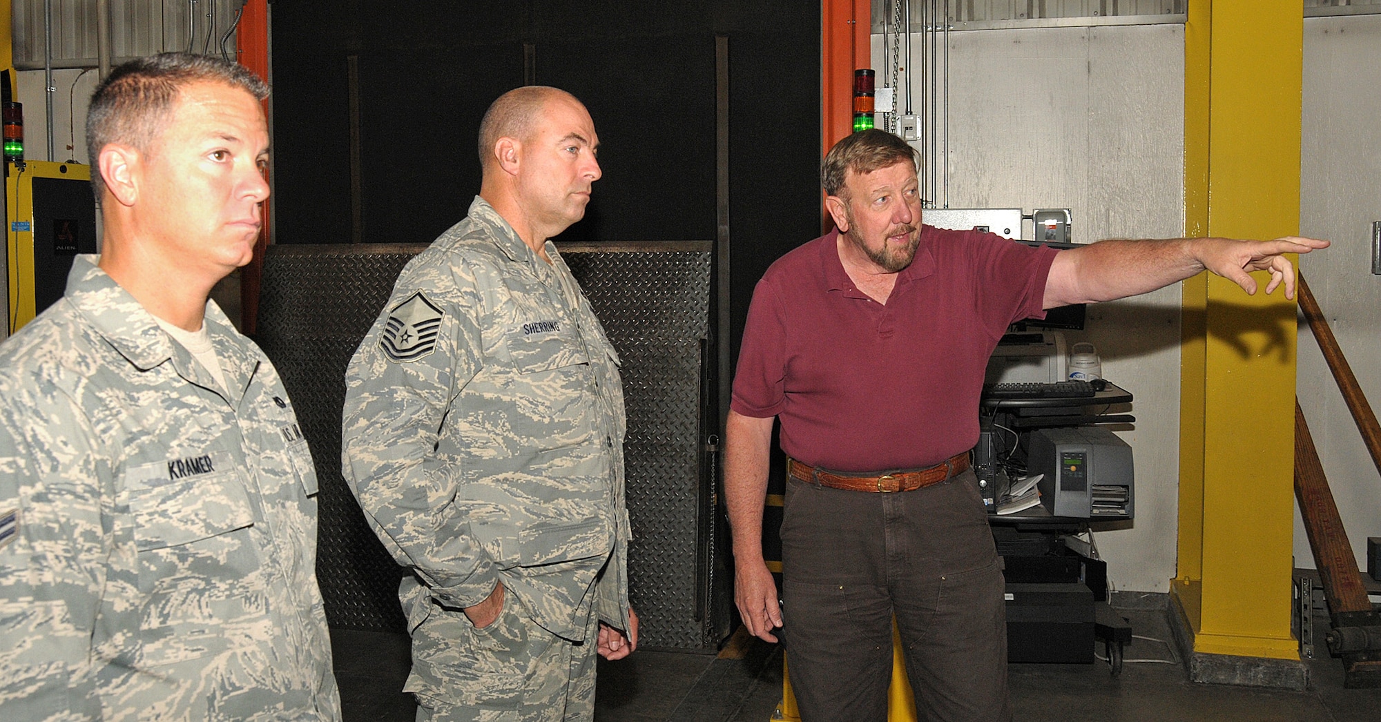 Mr, Charles Carr, Weight Supevisor 7 in Air Terminal Operations, conducts a tour of the terminal warehouse facility for Master Sergeant Burt Sherring and Airman First Class Jesse Kramer from the Air Terminal Operations Squadron, 146th Airlift Wing, Channel Islands Air National Guard Station, Calif.  on June 6, 2011. Mr. Carr briefed the members on the various equipment available to them as well as safety protocol.  The 146th AW sent three squadrons to Joint Base Elmendorf-Richardson, Anchorage, Alaska on Saturday, June 4, 2011. The Air Terminal Operations Squadron, Logistics Readiness Squadron, and the Security Force Squadron moved down range to complete there respective annual training requirements.(Photo by Tech. Sgt. Alex Koenig)