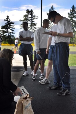 Senior Airman Daniel Boling, right, signs in before participating in the McChord Health and Wellness Center running clinic May 23 at Joint Base Lewis-McChord, Wash. The clinic video-tapes each runner and provides feedback via email. (U.S. Air Force photo/Airman 1st Class Leah Young) 
