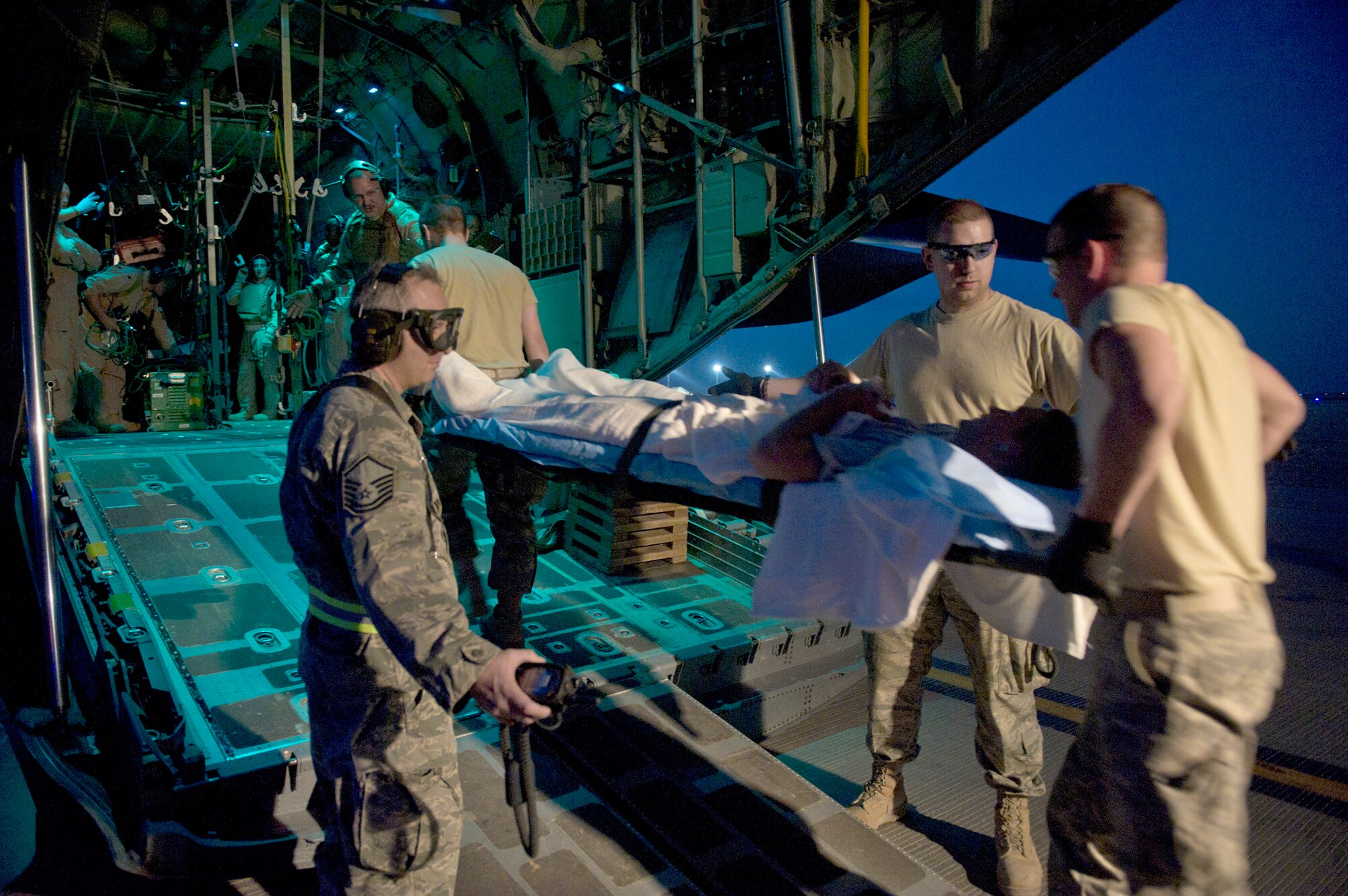 Members of the 451st Expeditionary Aeromedical Evacuation Squadron load a wounded Marine onto a C-130 Hercules May 21, 2011, at Camp Bastion, Afghanistan. (U.S. Air Force photo/Master Sgt. Adrian Cadiz)