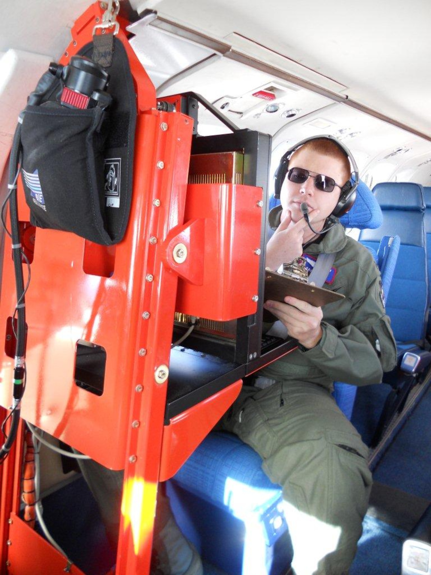 Capt. David Heinz, United States Air Force Test Pilot School Class 10B student, reads data displayed on a computer screen behind the cockpit of a C-12. He and 23 other students of Class 10B will receive Masters of Science in Flight Test Engineering when they graduate June 11. (Air Force photo)